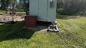 Um pequeno edifício térreo com telhado inclinado, porta e chaminé.