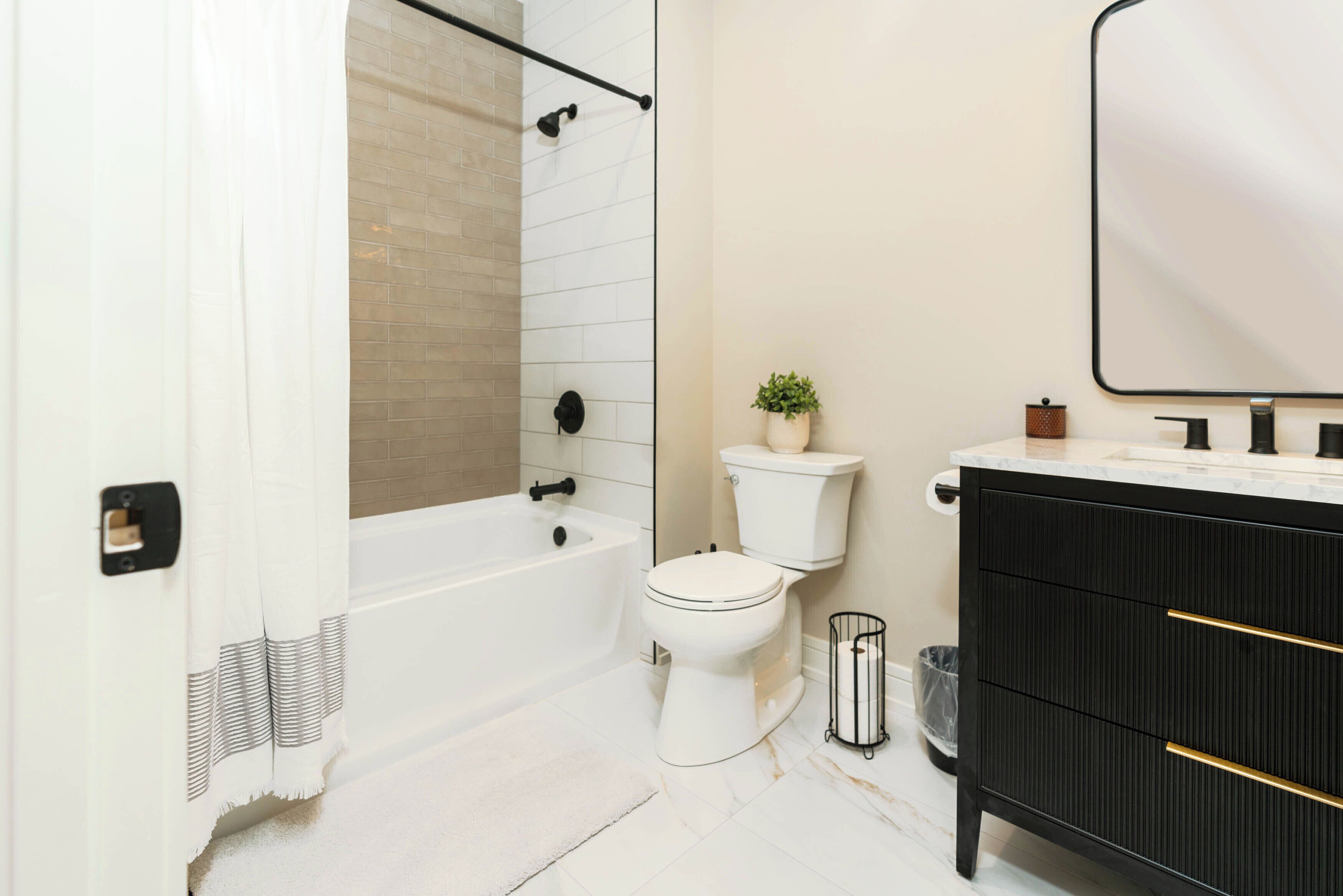 A bathroom with a bathtub, toilet, and vanity.