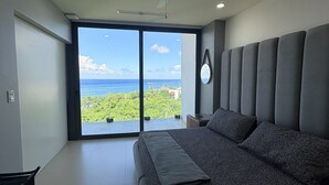 Ein Schlafzimmer mit einem großen Bett, einem Deckenventilator und Blick auf den Ozean.