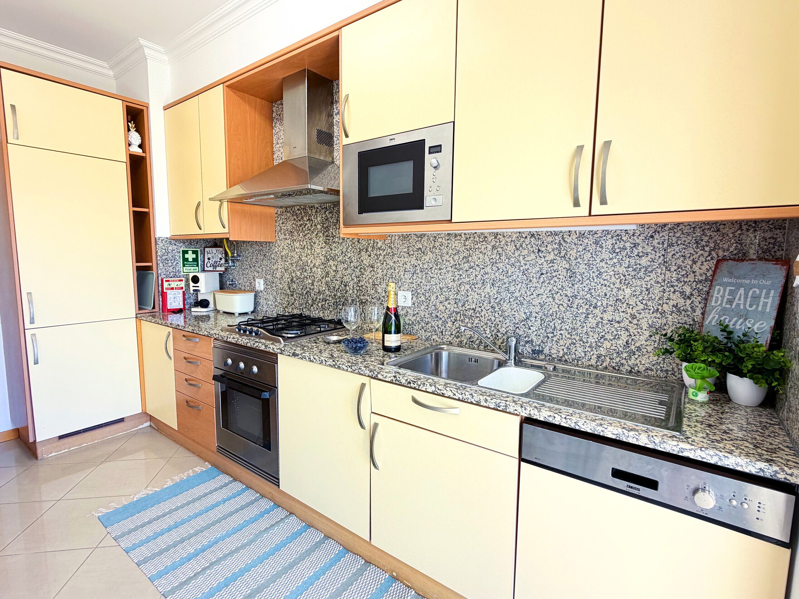 A kitchen with granite countertops, stainless steel appliances, and light-colored cabinetry.