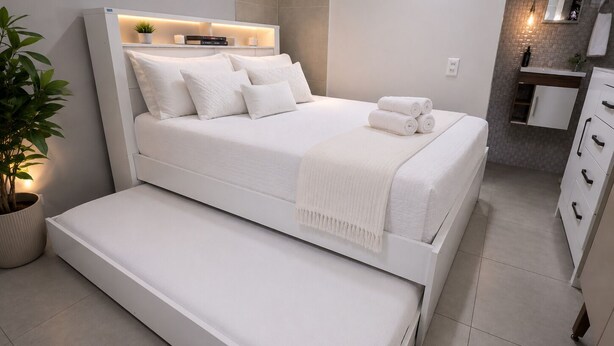 A modern bedroom with a bed, bedside table, and a small seating area.