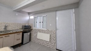 A compact kitchen with a microwave, sink, and cabinets.