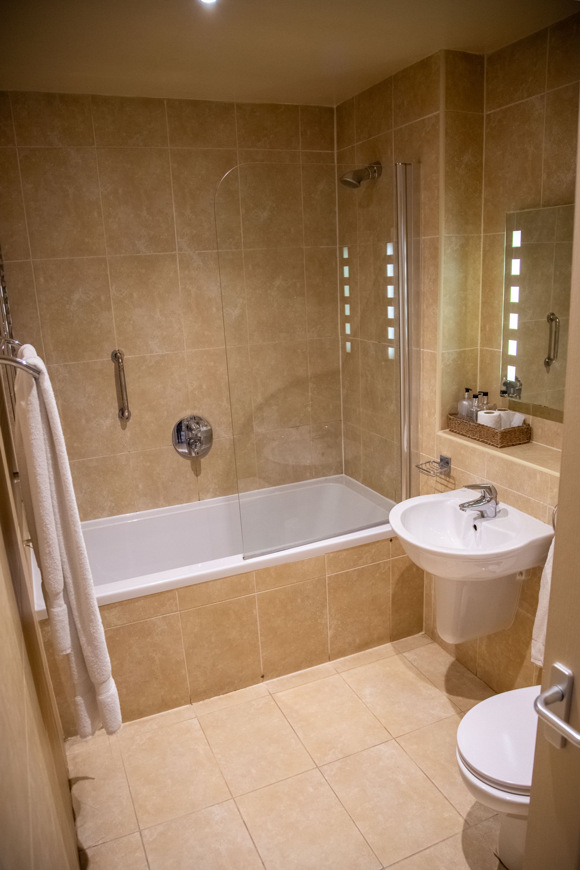 A modern bathroom with a bathtub, a shower, and a sink.