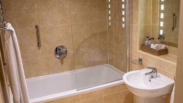 A modern bathroom with a bathtub, a shower, and a sink.