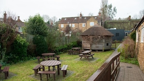 A backyard with picnic tables and a small wooden structure.