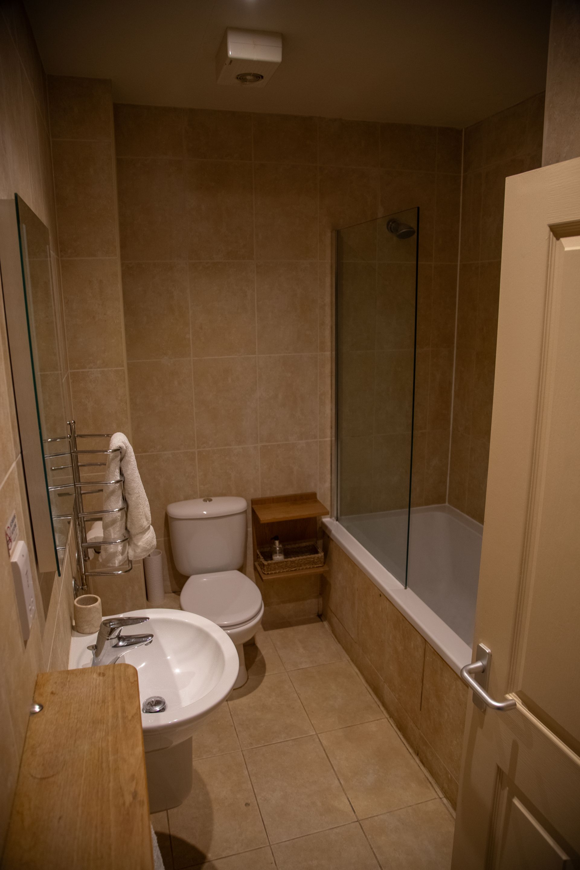 Un baño pequeño con inodoro, lavamanos y ducha.