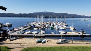 A marina with boats docked, a dock, and a mountain in the background.
