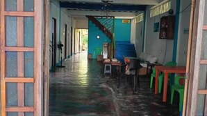An interior with a staircase, a hallway, and a seating area with chairs and tables. - Casa hostal playa coral  (Acandi)