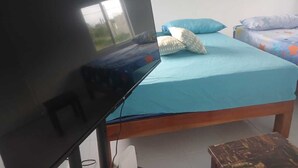 Ein Zimmer mit einem Bett, einem Fernseher und einem Fenster.