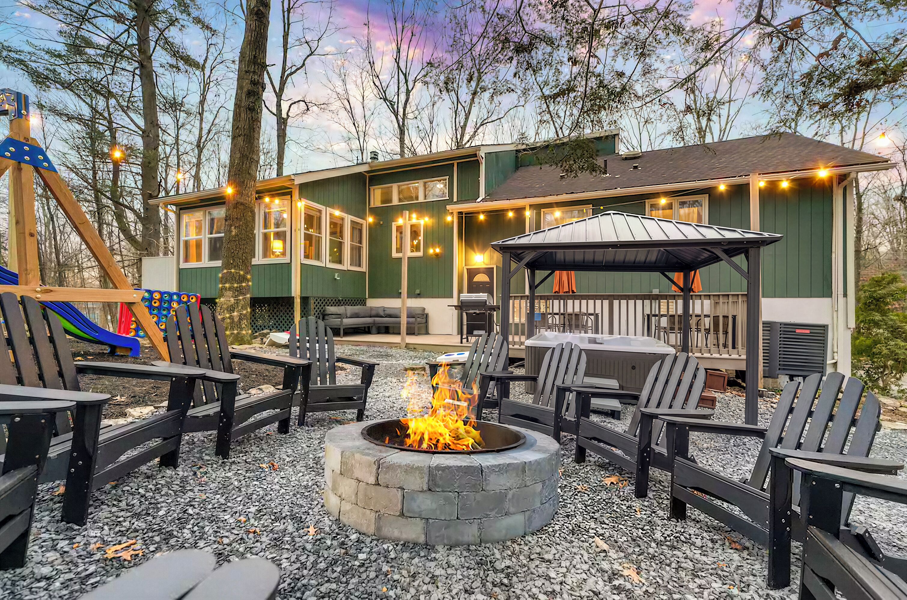 A house with a deck, outdoor seating, and a fire pit.