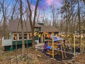 Ein Haus mit Spielbereich, Terrasse und kleinem Garten.
