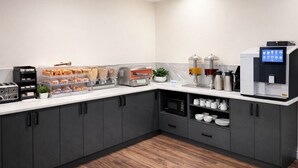 Una cocina moderna con cafetera, tostadora y una exhibición de pan.