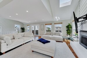 A spacious living room with two sofas, a coffee table, and a fireplace. - Croatan Beach Spacious 4BR Home with Views (Virginia Beach)