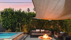 A poolside area with a fire pit, outdoor furniture, and a pool. - Palm Springs Mid-Century Home | Pool, Spa, Casita + Sweeping Mountain Views (Palm Springs)