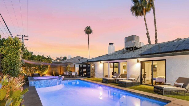 A swimming pool with lounge chairs, a patio area, and a modern house with large windows. - Palm Springs Mid-Century Home | Pool, Spa, Casita + Sweeping Mountain Views (Palm Springs)