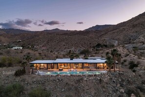 A modern house with a swimming pool, surrounded by rocky terrain and mountains. - Palm Desert Mountaintop Estate | Lap Pool & Spa, Valley Views & Outdoor Kitchen (Palm Desert)
