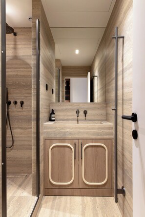 Une salle de bain moderne avec une douche, un lavabo avec un miroir et des meubles en bois.