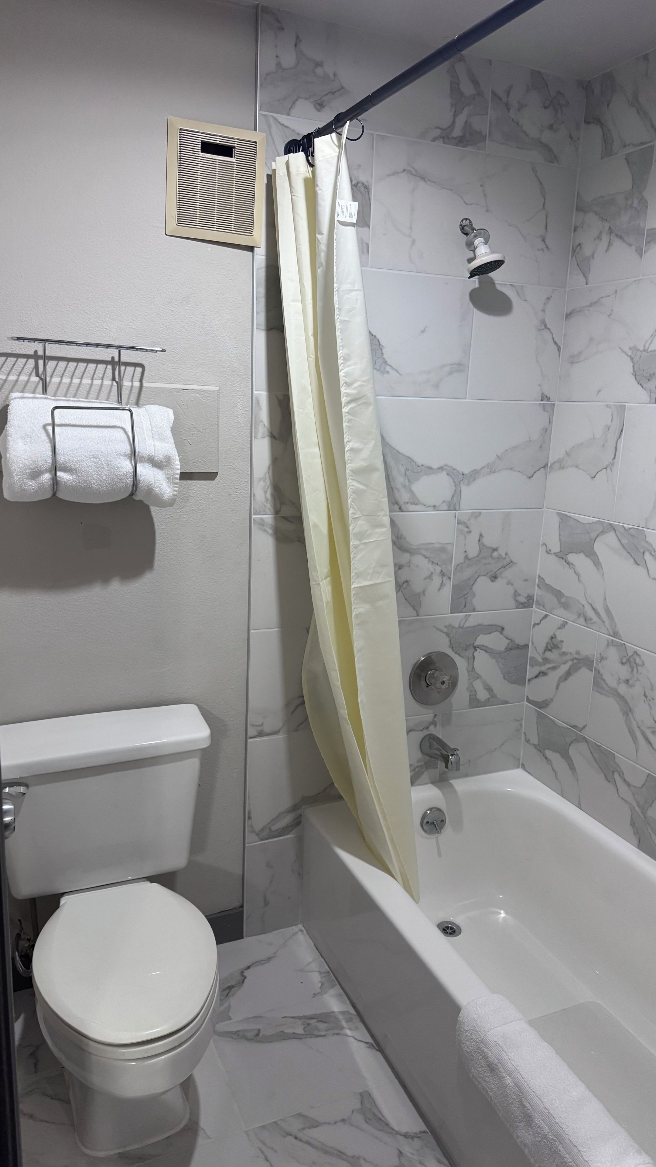 A bathroom with a toilet, a bathtub, and a shower.