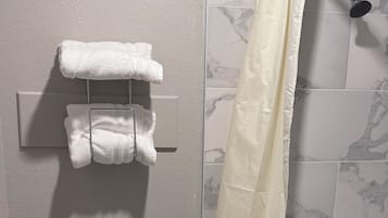 A bathroom with a toilet, a shower curtain, and a bathtub.