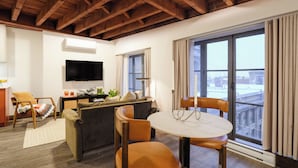 Una sala de estar con sofá, sillas, televisión y mesa de comedor.