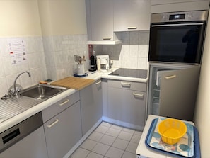 A compact kitchen with a sink, stove, microwave, and refrigerator. - Seafront apartment in Erquy | 4 guests | Ref 506 (ERQUY)