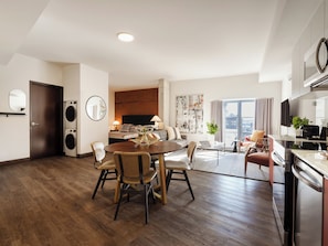 Une chambre d’hôtel moderne dotée d’un coin repas, d’une cuisine et d’une buanderie.