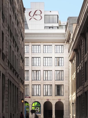 Un immeuble à plusieurs étages, dont la façade est ornée d’un logo bien visible, avec de nombreuses fenêtres et une enseigne indiquant un commerce appelé « Bresoles ».