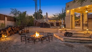Un espace patio avec un foyer, du mobilier d’extérieur et une zone piscine.