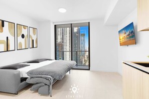 A modern bedroom with a bed, a window with a city view, and a painting on the wall. - Light‑Filled Chic Studio in Miami (Miami)