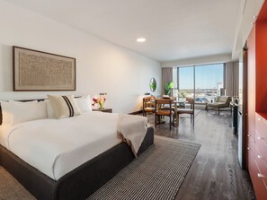 A hotel room with a large bed, a desk, and a view of the city. - Loft | Serviced Apartment Old Montreal, King Bed, Full Kitchen (Montréal)