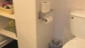 Kylpyhuone, jossa on wc, hylly hygieniatuotteille ja roskakori.