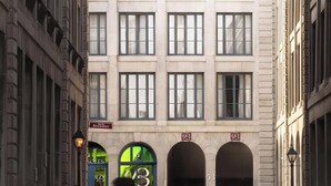 A multi-story building with a prominent logo on the facade, multiple windows, and a sign indicating a business named 'Bresoles.' - Loft with Balcony | Furnished Apartment Old Montreal, Accessible (Montréal)