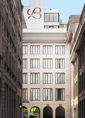 Un immeuble à plusieurs étages, dont la façade est ornée d’un logo bien visible, avec de nombreuses fenêtres et une enseigne indiquant un commerce appelé « Bresoles ».