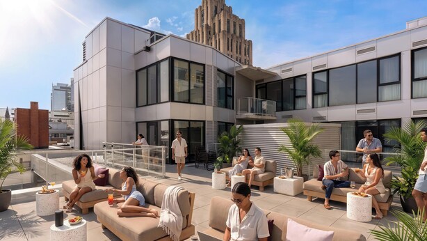Um lounge no terraço com assentos externos, um edifício moderno ao fundo e céu claro.
