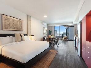 A modern hotel room with a large bed, a dining area, and a view of the city. - Loft with Balcony | Apartment Old Montreal, River View, Accessible (Montréal)