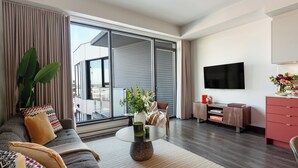 Ett modernt vardagsrum med en soffa, ett soffbord och en tv.