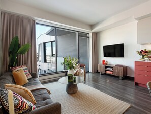 Ein modernes Wohnzimmer mit Sofa, Couchtisch und Fernseher.