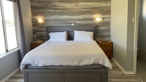 Ein Schlafzimmer mit einem Bett, Nachttischen und Wandleuchten.
