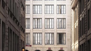 Ein mehrstöckiges Gebäude mit einem gut sichtbaren Logo an der Fassade, zahlreichen Fenstern und einem Schild, das ein Geschäft namens 'Bresoles' anzeigt.