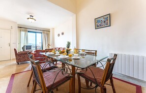A dining area with a glass table, wicker chairs, and a breakfast setting. - 3 bedroom awesome home in Almuñecar (Almuñecar)