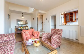 A living room with a sofa, armchair, and coffee table with fruit. - 3 bedroom awesome home in Almuñecar (Almuñecar)