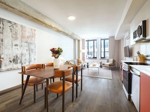 A modern living room with a dining area, a kitchen, and large windows. - One-Bedroom Suite | Spacious Open Apartment Old Montreal, Natural Light, Fu (Montréal)