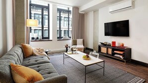 Een moderne woonkamer met een bank, salontafel en televisie.