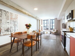 A modern living room with a dining area, a kitchen, and large windows. - One-Bedroom Suite|Spacious Apartment Old Montreal, Natural Light (Montréal)