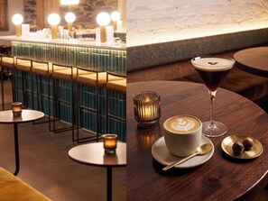 Eine Bar mit Hockern, einem runden Tisch mit Kerze, einer Kaffeetasse mit Latte-Art und einem Martini-Glas.