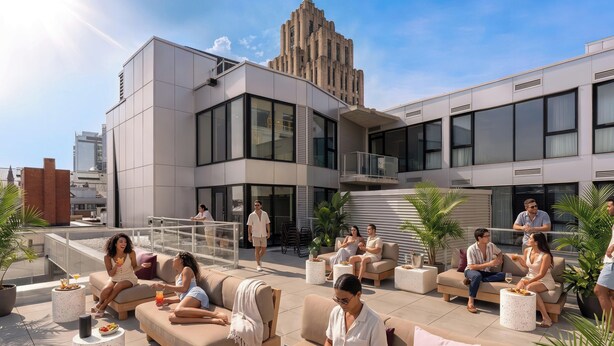 Una terrazza panoramica con posti a sedere all'aperto, uno stabile moderno sullo sfondo e un cielo sereno.