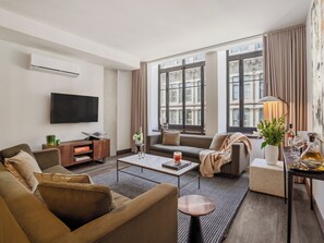 Ein modernes Wohnzimmer mit Sofa, Couchtisch und Fernseher.