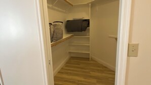 A narrow hallway leading to a closet with shelves and a hanging rod. - Mesa Nomad Mecca refreshing Diving Pool + splash pad & patio, Dog friendly! (Mesa)