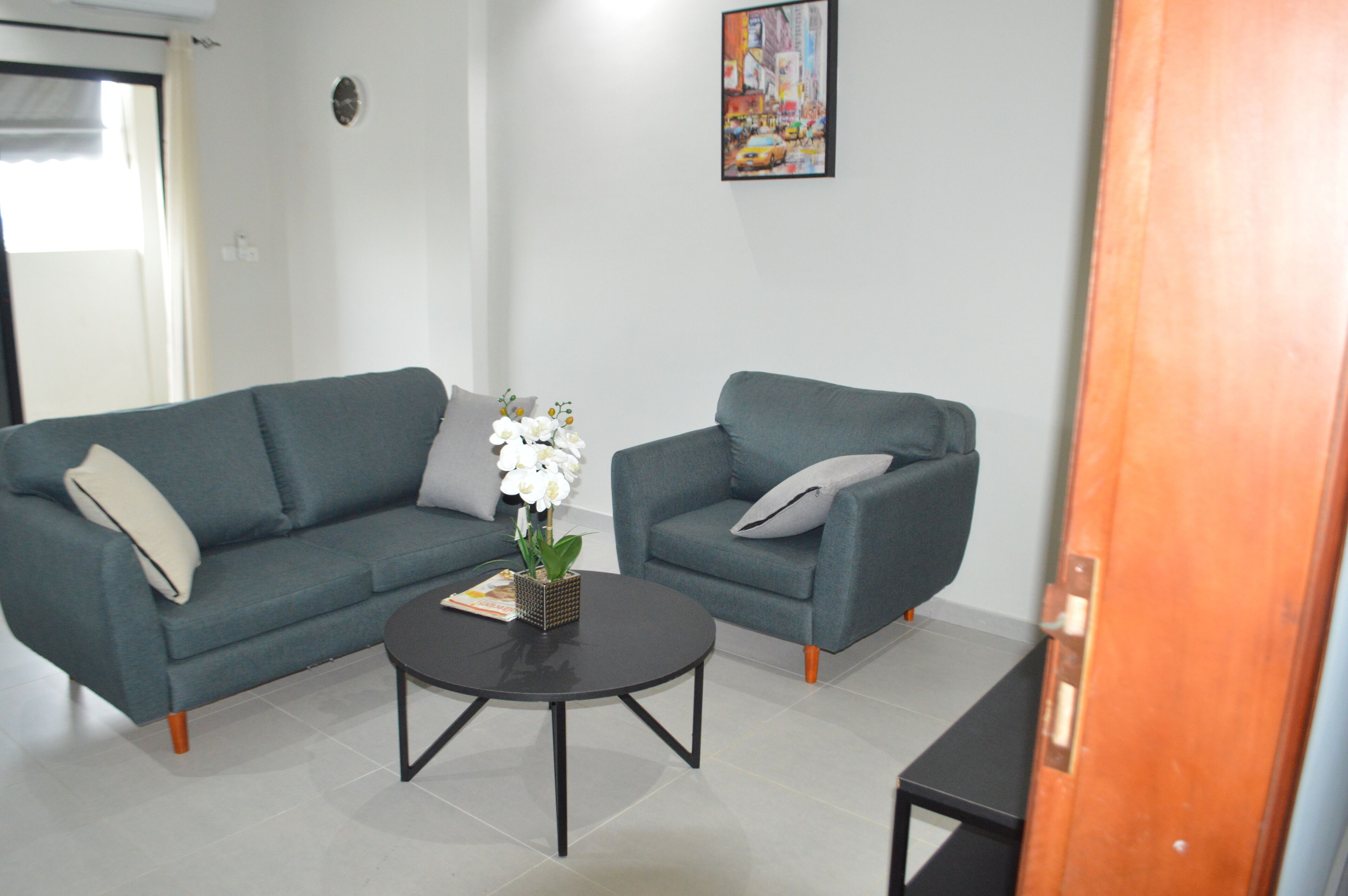 A modern living room with two sofas, a coffee table, and a door.