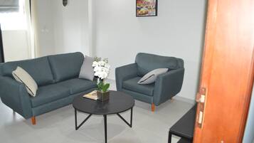 A modern living room with two sofas, a coffee table, and a door.